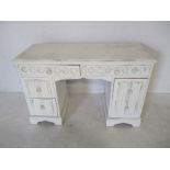 A white painted desk with linen fold decoration