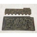 A 17th century carved wooden panel depicting two cherubs, rams heads and mythical bird along with