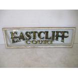 A large wooden framed gilt on glass painted sign "Eastcliff Court", 166cm x 50cm