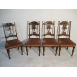 A set of four art nouveau dining chairs with carved decoration