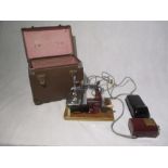 An Essex electric portable miniature sewing machine in carry case