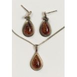 An amber pendent and matching earrings set in silver