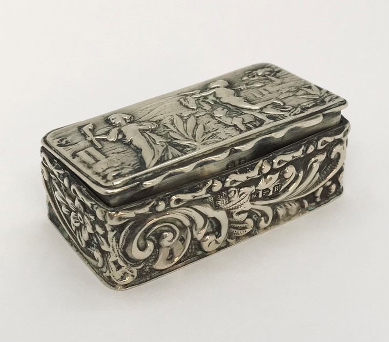 A small hallmarked silver pill box ( Chester 1900, George Nathan & Ridley Hayes) decorated with a