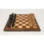 A carved wooden Asian chess set on wooden board with velvet lined carry case