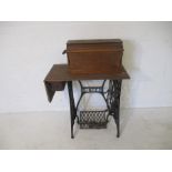 A "Singer Manufacturing Co" iron framed treadle sewing table with integrated Singer sewing machine