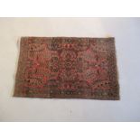 A Persian red ground rug - overall size 110cm x 70cm