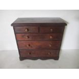 A stained pine chest of five drawers