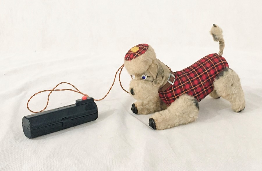 A battery operated Scotty dog with tartan coat. Light up eyes and movable legs and tail