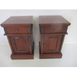 A pair of dark wood bedside cabinets