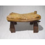 A vintage camel saddle stool with leather cushion seat