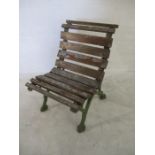 An antique cast iron garden chair with wooden slatted seat
