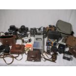 A collection of various cameras, binoculars, camera accessories etc, including Zenit, Praktica,