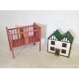 A vintage baby's crib along with a small dolls house