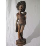 A carved wooden figure of a Balinese girl, height 60cm