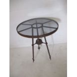 A circular glass topped garden table with metal base