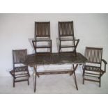 A weathered wooden garden table, along with four matching chairs