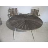 A vintage circular garden table with two matching chairs
