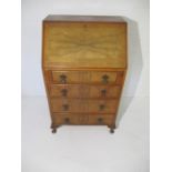 A walnut veneer bureau with four drawers