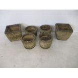 A collection of six concrete garden pots