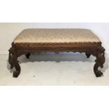 A turn of the century Anglo-Indian footstool with stylised dragon feet - length 85cm depth 56cm