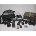 An Olympus E-300 8.0 Megapixel camera along with accessories in carry bag, along with three others