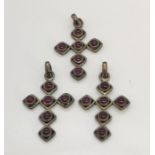 Three silver crosses set with garnets