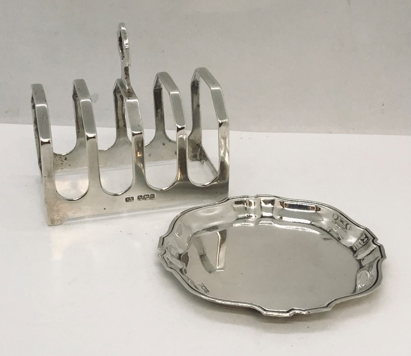 A hallmarked silver toast rack along with a silver pin dish