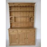 A pine dresser with three drawers and two cupboards under - height 217cm, width 136cm, depth 46cm