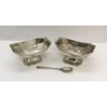 A pair of silver salts with one spoon