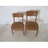 A near pair of wooden children's school chairs