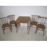 A blond Ercol dropleaf table and four chairs.