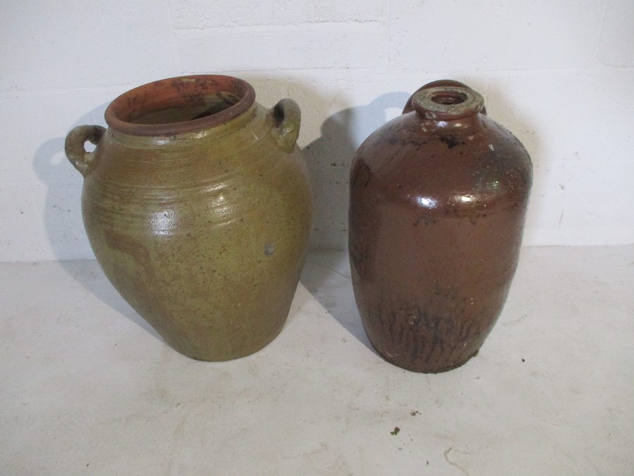 A large two handled glazed terracotta urn along with a large flagon