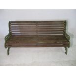 A wooden slatted garden bench with cast iron ends