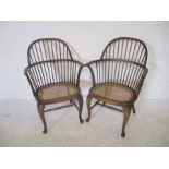 A pair of stick back Windsor carvers with cane seats