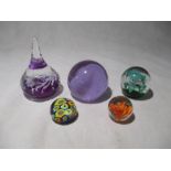 A collection of five glass paperweights including Caithness