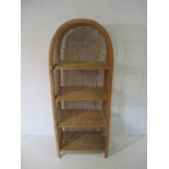 A vintage rattan domed shelving unit