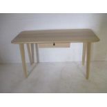 A contemporary console table with single drawer