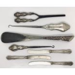A collection of silver handled items including shoe horn, tongs, button hooks etc.