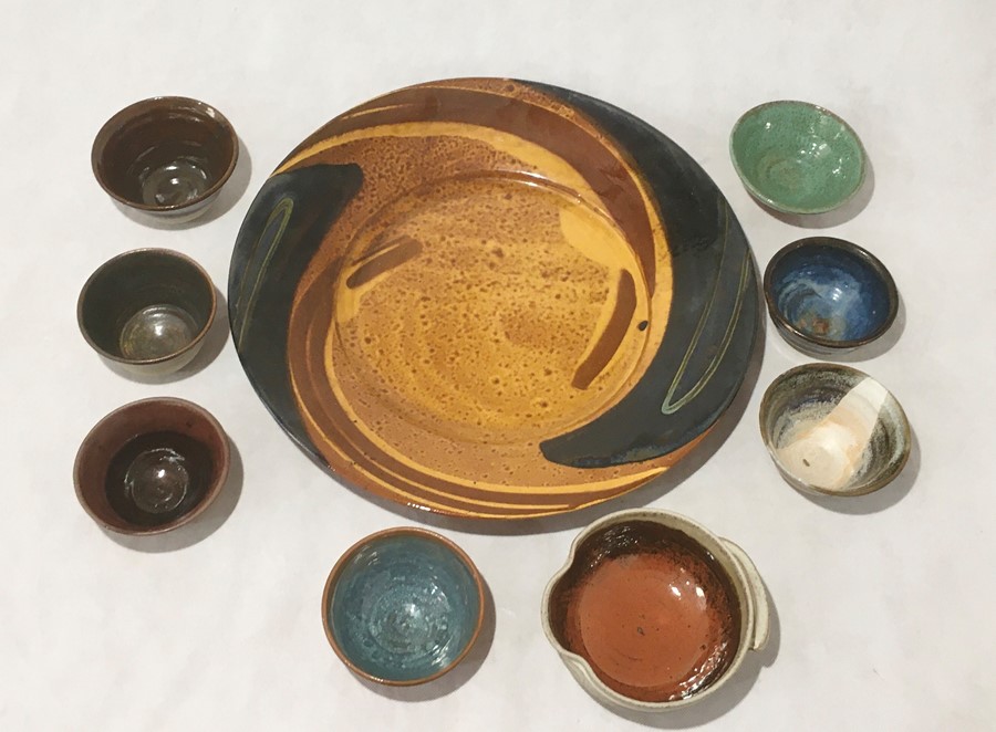 A large Eden pottery charger along with a collection of studio pottery bowls