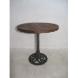 A cast iron garden table with wooden top.