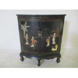 A Chinese lacquered bow fronted two door corner cupboard decorated with hardstones.