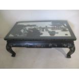 A Chinese lacquered coffee table decorated with a traditional scene and foliage. 107cm x 62cm and