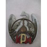 A vintage Polish Automobile Club car badge with eagle holding a steering wheel with enamelled "KPM"