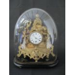 An ornate French ormolu mantle clock under a dome