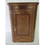 A Georgian inlaid corner cupboard with drawer under