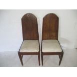 Two high back upholstered dining chairs with antique rustic backing.