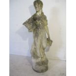A weathered reconstituted stone statue of a lady holding a basket, Height 142cm