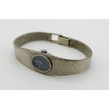 A ladies 9ct white gold Omega Bracelet Watch, dark blue oval face with baton markers, integral