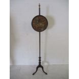 A Victorian pole screen on tripod base with claw and ball feet
