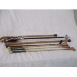 A collection of riding crops, shooting stick etc.